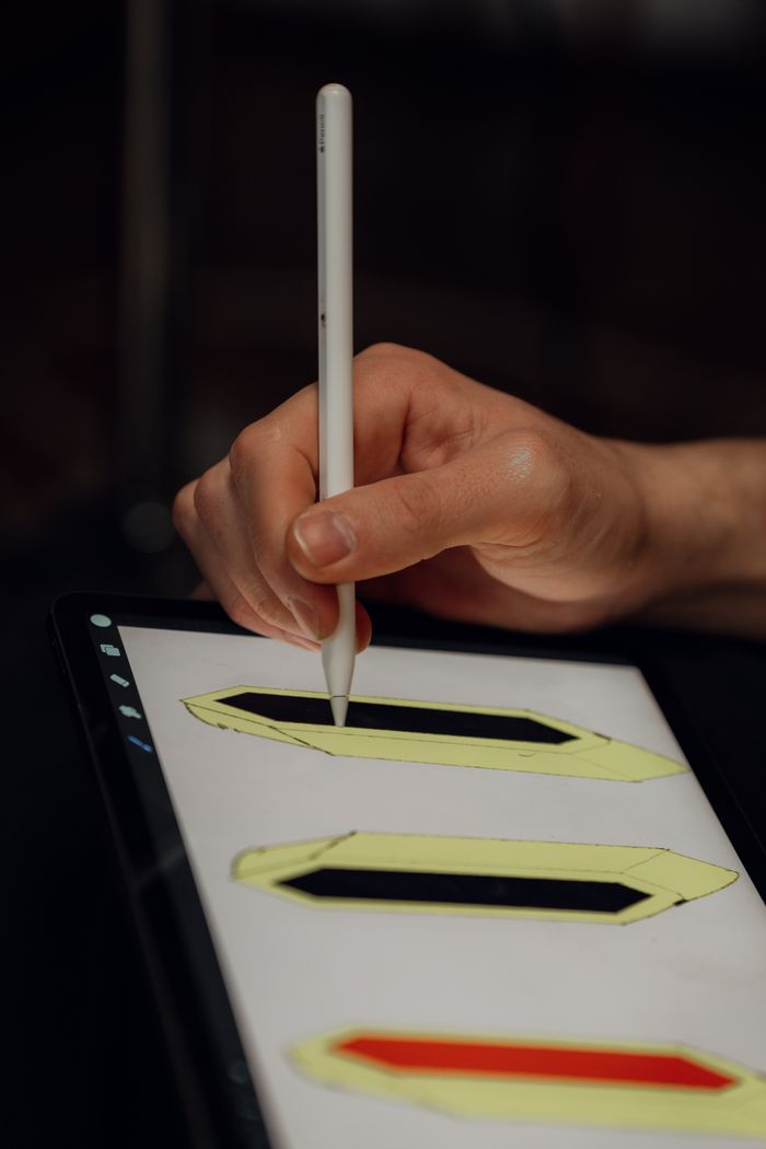 gallery-3 A person using a stylus pen to draw geometric shapes on a digital tablet screen.